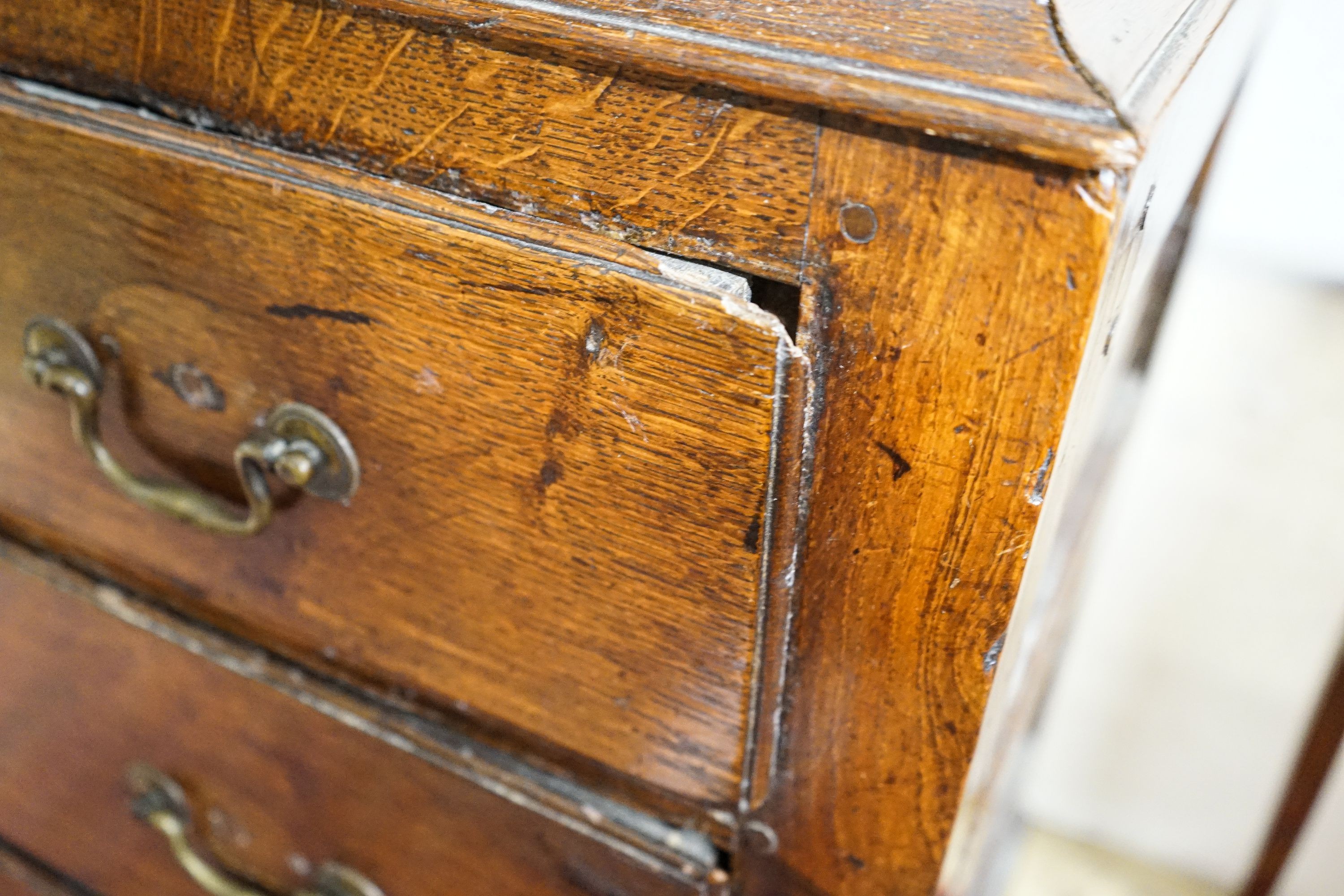 A George III oak press cupboard, with moulded cornice and two panelled doors over five drawers, width 122cm, depth 52cm, height 183cm